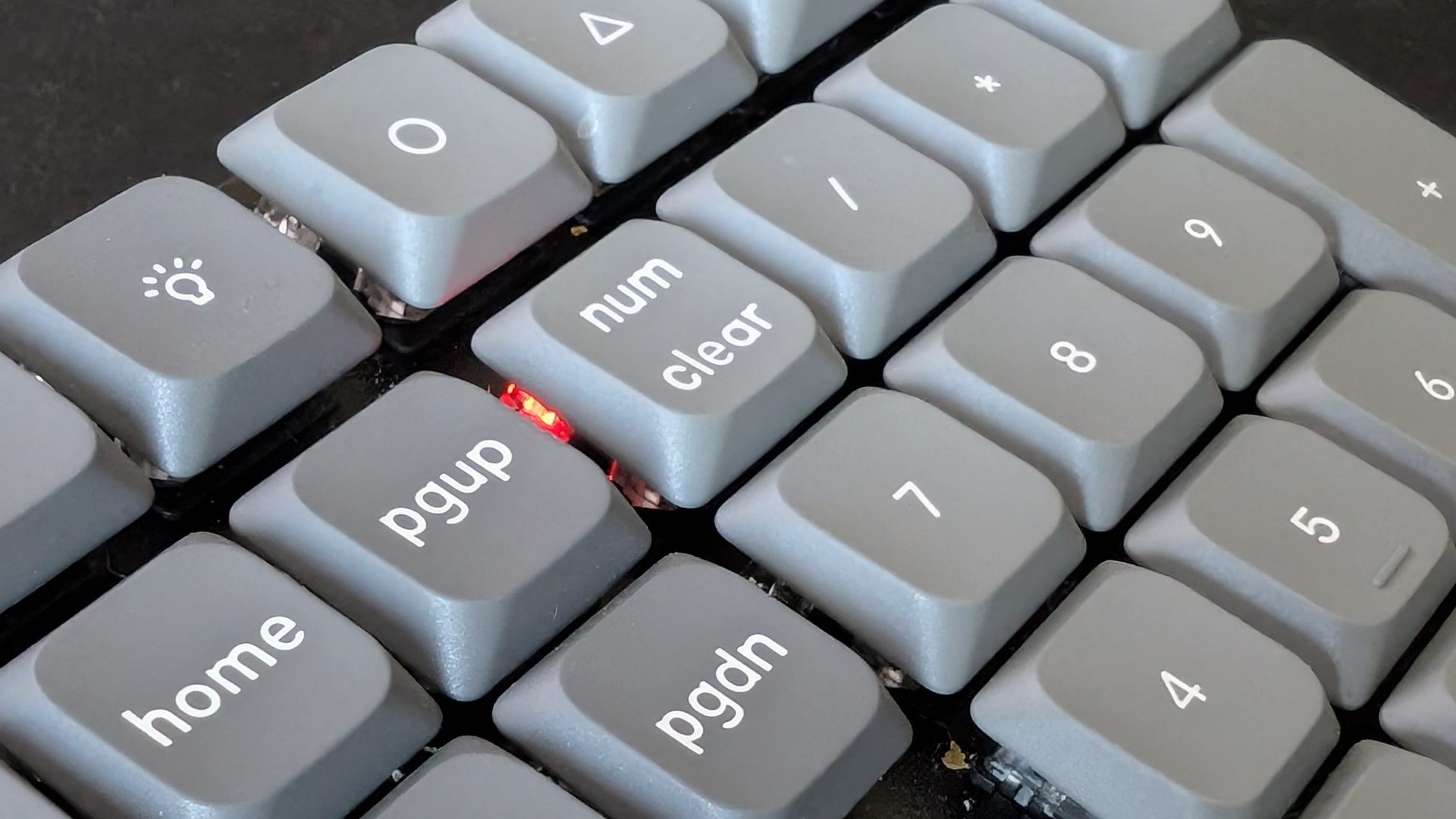 closeup view of a computer keyboards numeric keypad featuring keys labeled home pgup num and clear with some keys highlighted in grey digital production Close-up view of a computer keyboard's numeric keypad featuring keys labeled 'home,' 'pgup,' 'num,' and 'clear,' with some keys highlighted in grey.
