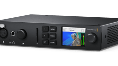 a blackmagic design video switcher with a small screen displaying a video feed buttons for menu and settings and various inputoutput ports on the front panel digital production A Blackmagic Design video switcher with a small screen displaying a video feed, buttons for menu and settings, and various input/output ports on the front panel.